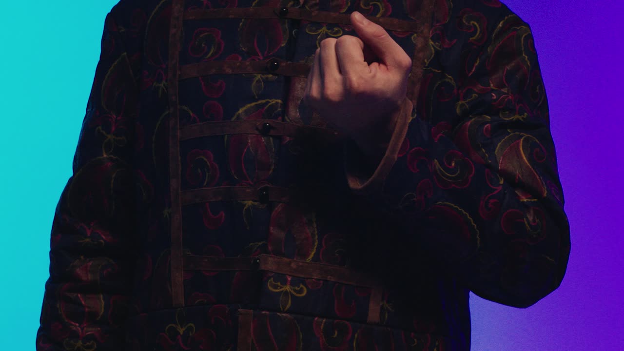 장식적인 셔츠를 입은 남자가 마법 트릭을 하는 클로즈업