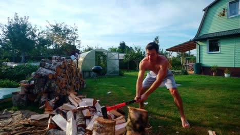 Toma-En-Cámara-Lenta-De-Un-Hombre-Rompiendo-Con-Fuerza-Un-Tronco-Usando-Un-Hacha-Durante-El-Verano-En-Lituania,-Europa.