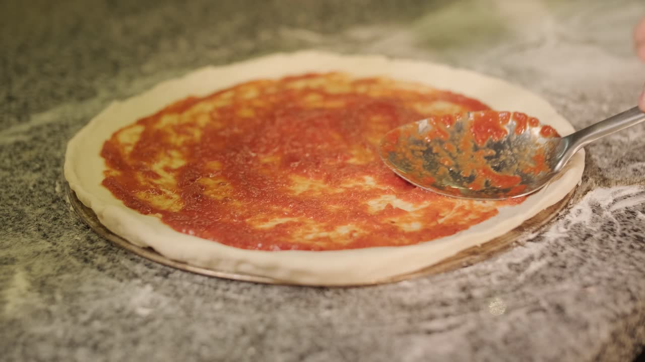 Uomo che cucina la pizza nella cucina di un ristorante
