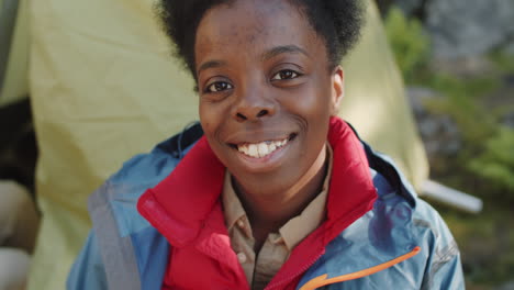 portrait of happy black female tourist at campsite