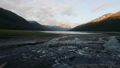 Agua-Dulce-Que-Fluye-A-Través-De-Un-Arroyo-Rocoso-Con-Vistas-A-Las-Montañas-En-Anchorage,-Alaska