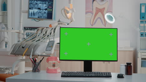 monitor con pantalla verde en el escritorio en el despacho vacío del dentista
