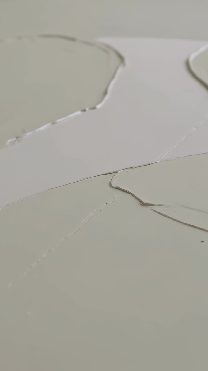 Video verticale: Telecamera in movimento che rivela tre chiazze grigio chiaro su un pannello bianco, esponendo una sottile cucitura.