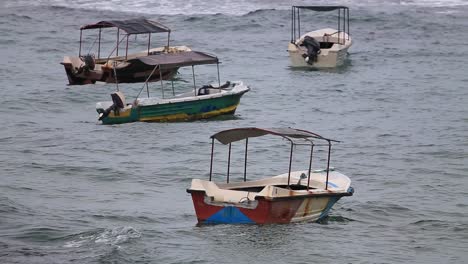 Vista-Estática-De-Cuatro-Lanchas-A-Motor-No-Tripuladas-Flotando-En-Las-Aguas-Turbulentas-Del-Mar-En-Hikkaduwa,-Sri-Lanka,-En-Diciembre-De-2014.