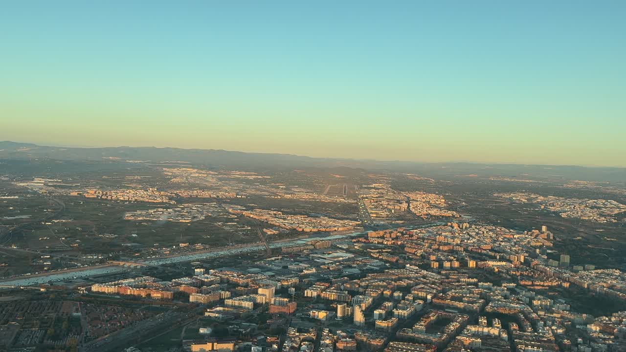 A pilot’s FPV of Valencia city with the airport and river flooded after devastating floods. Aerial view from an airplane cockpit arriving to the airport at sunrise. 4K 60FPS