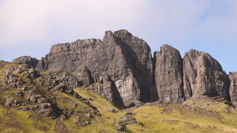 looking up at the black cliff faces of the old man of storr hike on isle of skye, highlands of scotland