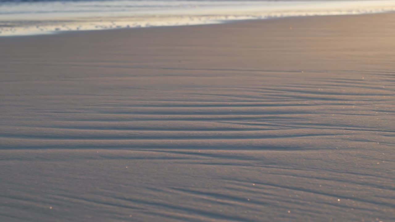 Slow camera panning revealing rippled wet sand texture for designers and marketers' backgrounds