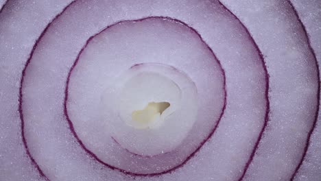 texture red onion rings rotating, close-up top view. harvested  healthy food background with vegetable of rich vitamin. sweet red spanish onion macro shot. food background closeup sliced purple onion