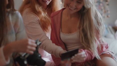 happy teenage girls taking photos together using instant photo camera best friends hanging out at home on weekend enjoying friendship