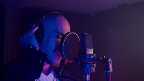hombre cantando en un micrófono en un estudio de grabación