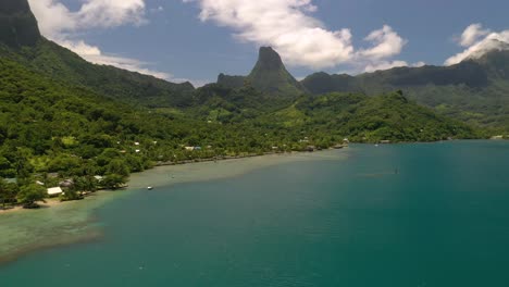 Aerial-shot-flying-over-turquoise-color-sea-towards-Mo'orea-island-coastline-in-French-Polynesia