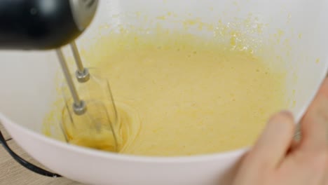 clip of egg yolks and powdered sugar mixed with electric mixer for tiramisu
