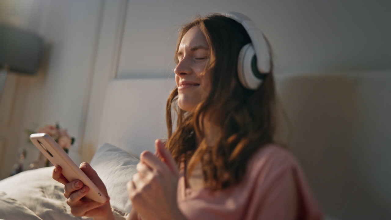 행복한 소녀가 집에서 음악을 듣고 있다. 무관심한 예쁜 여자 노래를 선택하라.