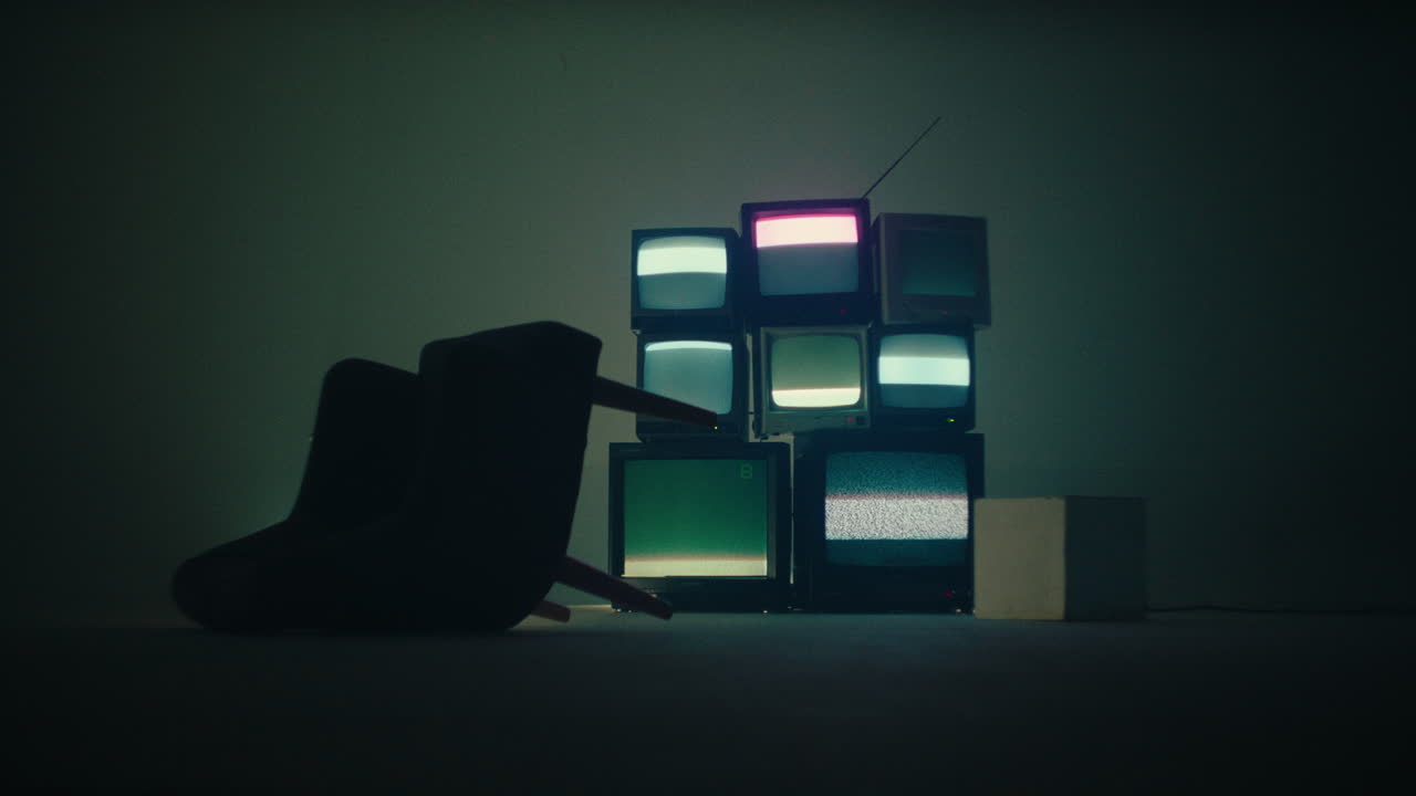 chair flip over in a media room studio with old crt monitor displaying glittering noise signal wide angle