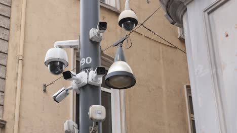 security cameras and a street light on a pole in a city street