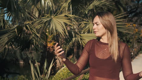 una mujer joven hablando emocionalmente en un chat de video al aire libre.