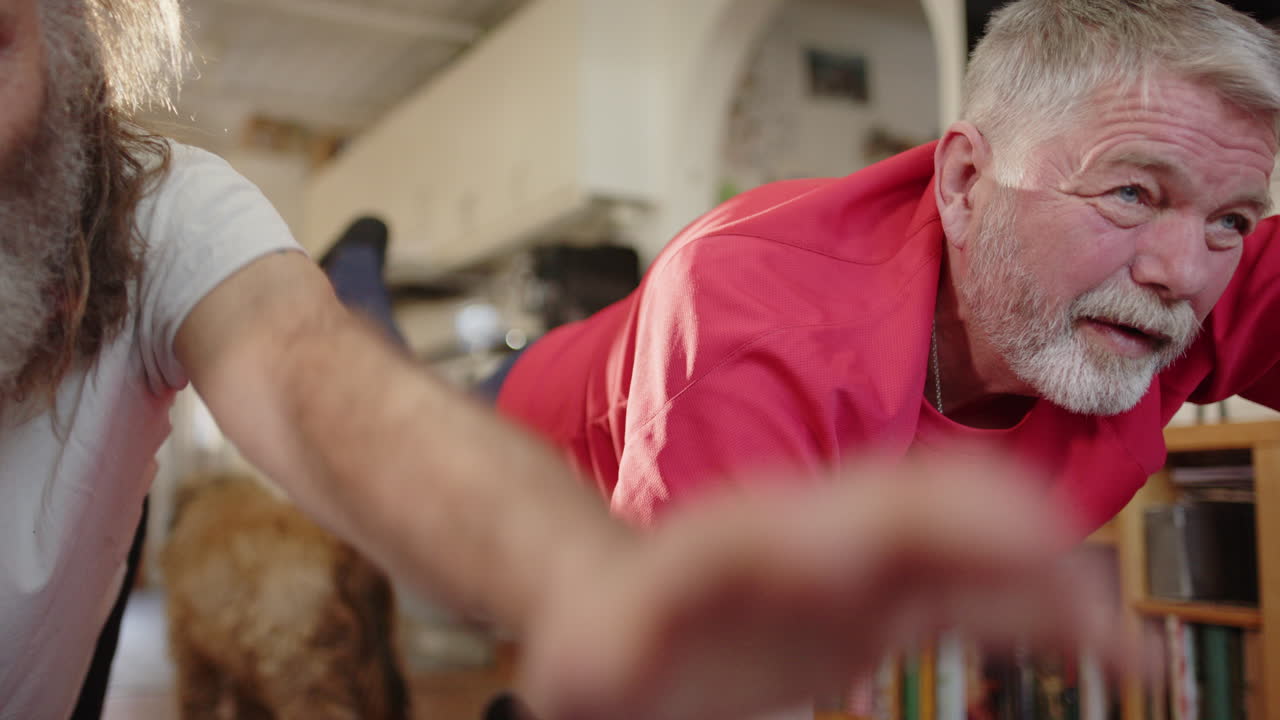 Elderly mates have laugh as they do yoga exercises together at home, closeup