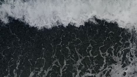 ocean waves dramatically form crashing waves and textured patterns from a top down view from a drone in the philippines