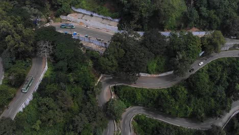 curvas cerradas en yercaud, india, cubiertas de un vasto bosque interminable con árboles que crecen rápidamente, vehículos que pasan por la carretera
