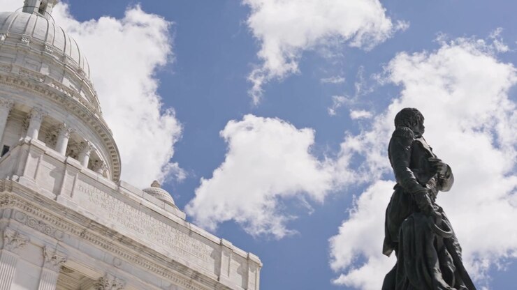 Movimento di tilt cinematografico verso il basso dalla cupola di marmo del Campidoglio del Rhode Island al Monumento a Oliver Hazard Perry nel centro di Providence in una soleggiata giornata estiva.