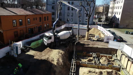 concrete vehicle pour cement with long arm in construction site, aerial view