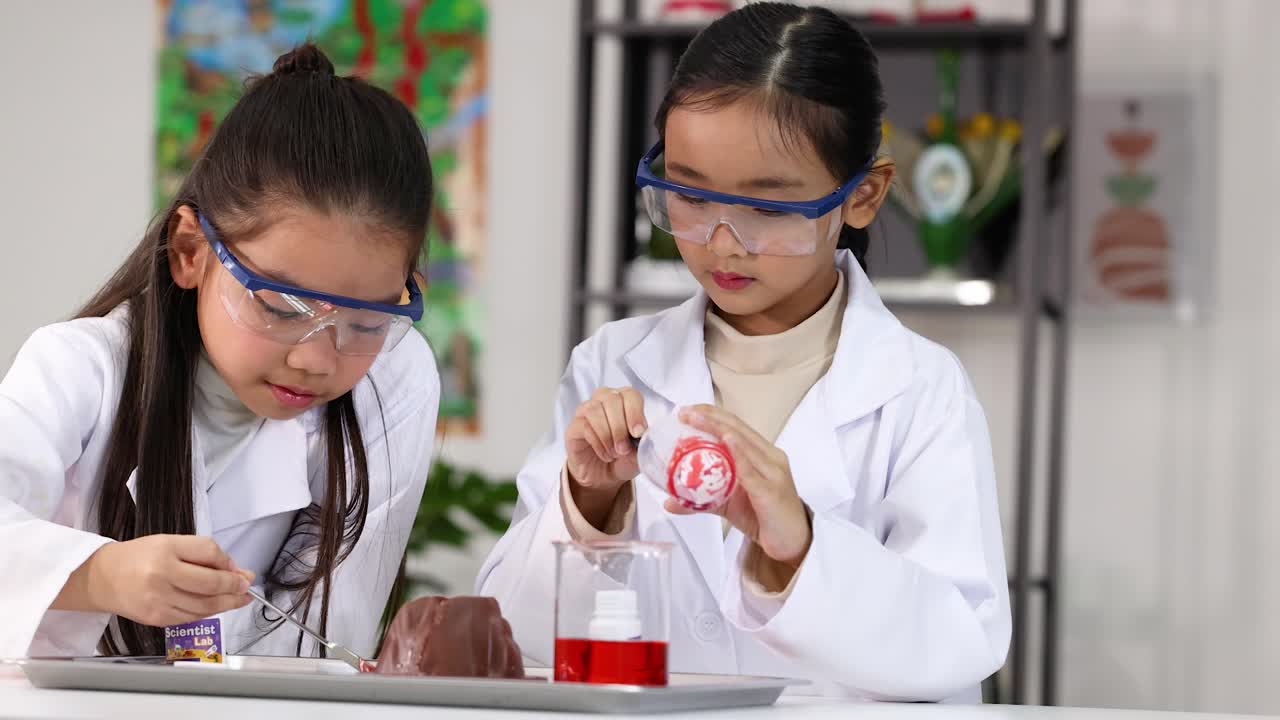 Dua Gadis Muda Mengenakan Jas Lab Melakukan Percobaan Sains