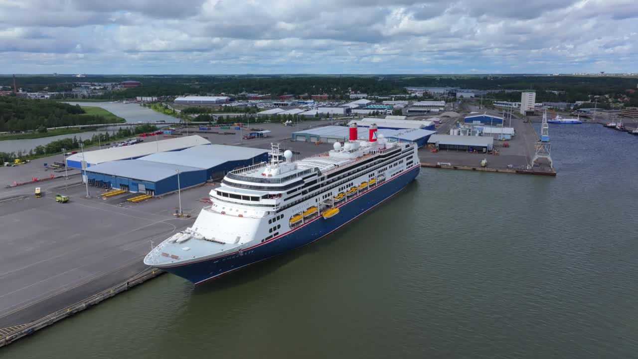 Fred.Olsen Cruise Lines passenger ship BOREALIS alongside in port. Lifeboat lowered for training. Moving aerial side view.