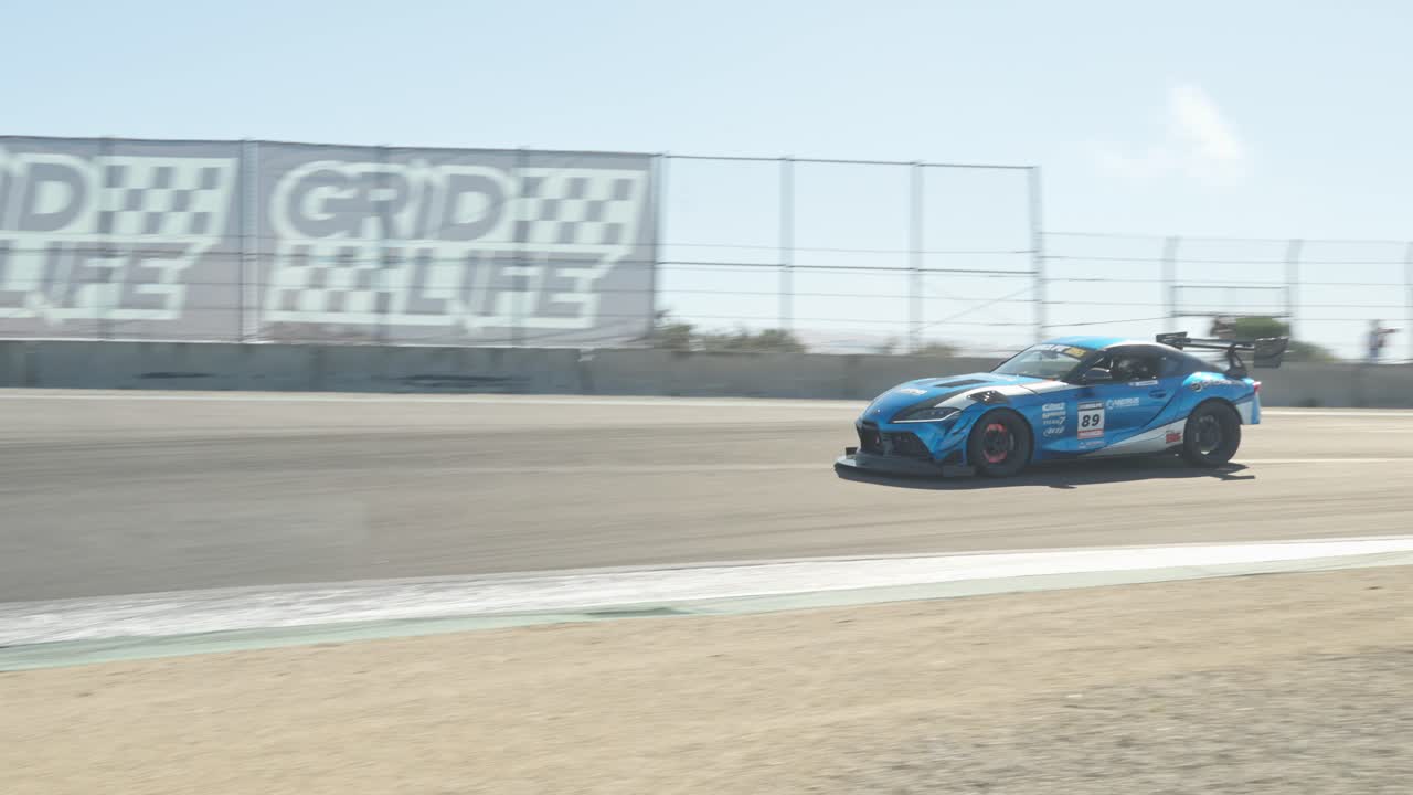 A powerful sports car accelerates on the race track, every movement of its engine and tires highlighted in crisp 60 fps slow motion.