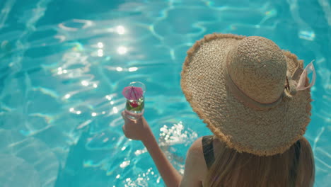 mujer disfrutando de un cóctel en una piscina