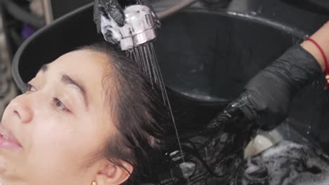 latina woman receiving professional hair treatment for scalp and hair health