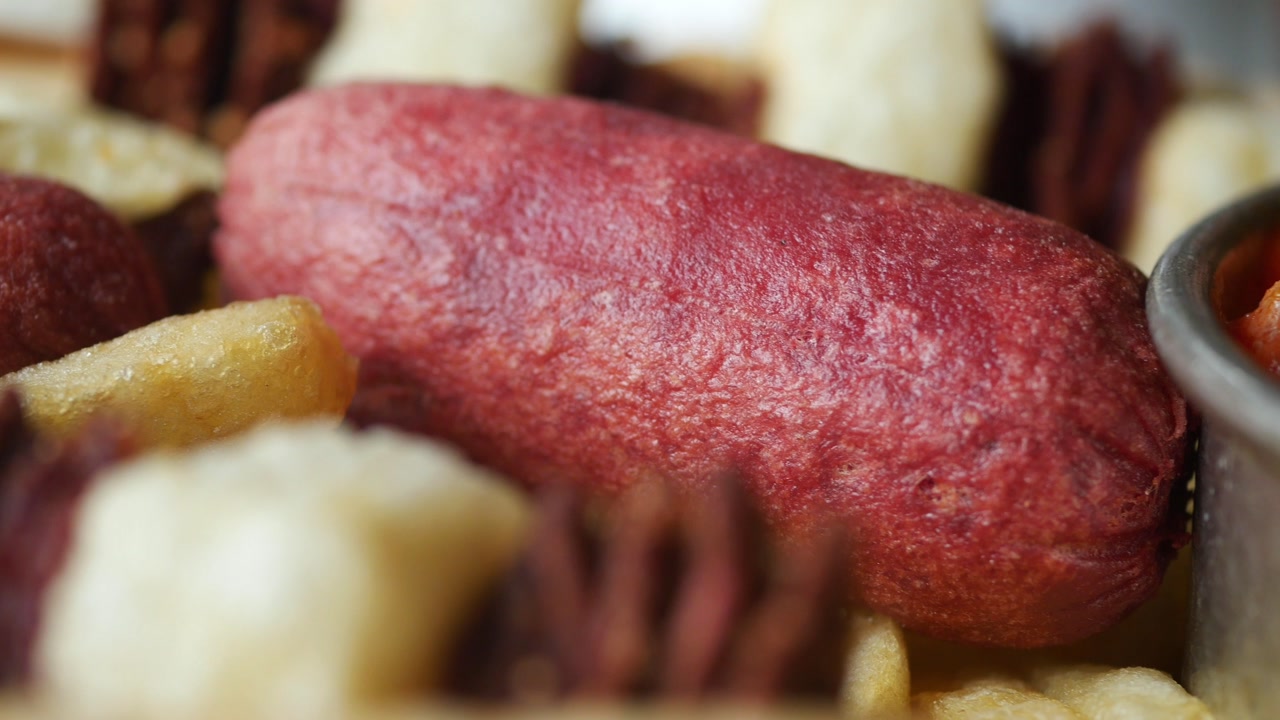 Close-up of a Deep-Fried Mini Hot Dog with Dipping Sauce