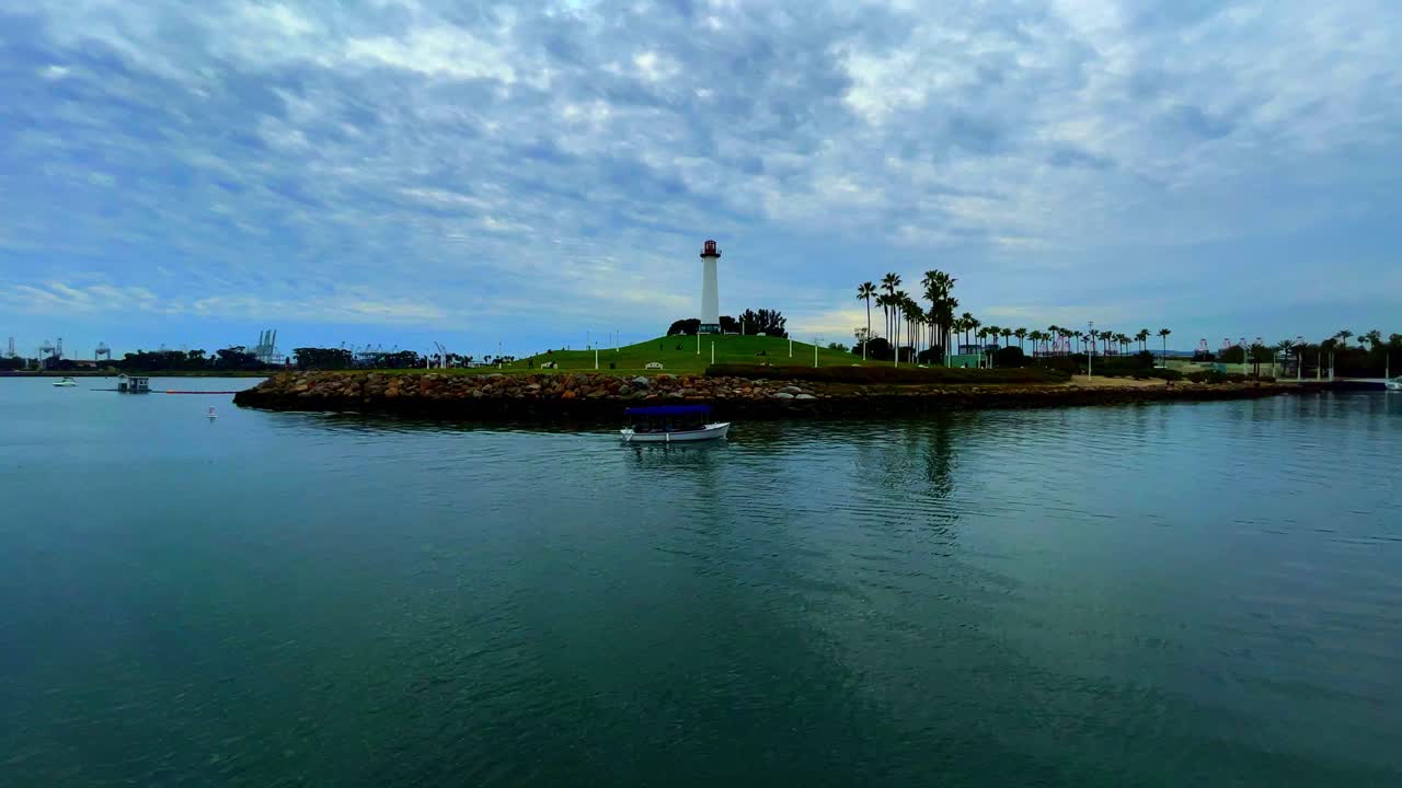 캘리포니아 롱 비치 항구에 있는 등대 앞을 가로지르는 보트의 광각 사진