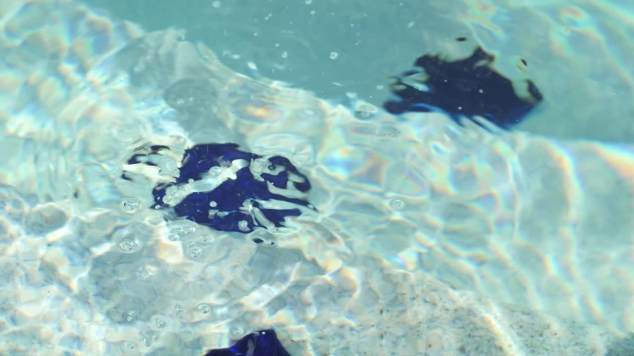 Bubbles popping in the water from a pool filter on the steps in slow motion