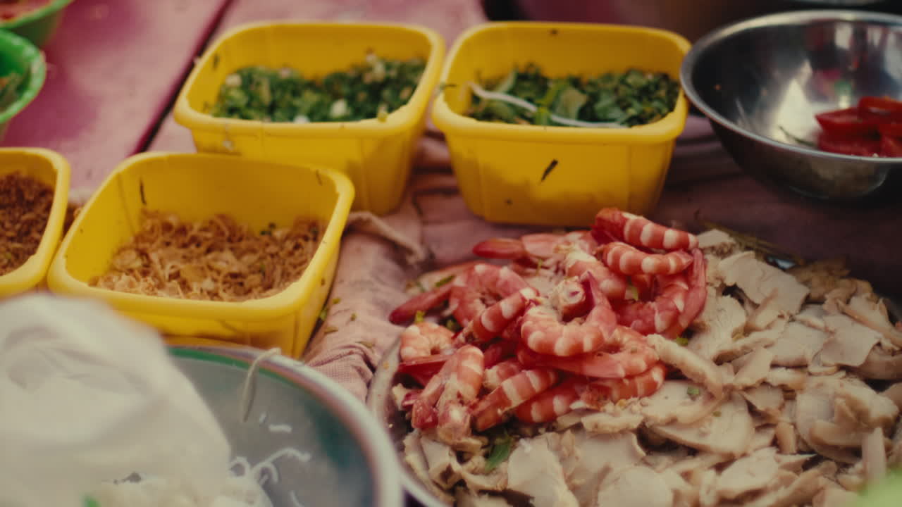 Fresh Vietnamese street food ingredients, shrimp, pork, and herbs on a market stall
