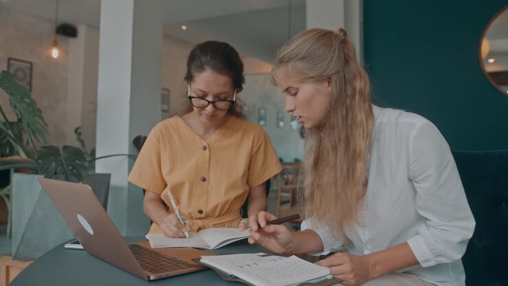 Donne d'Affari che Collaborano in un Caffè