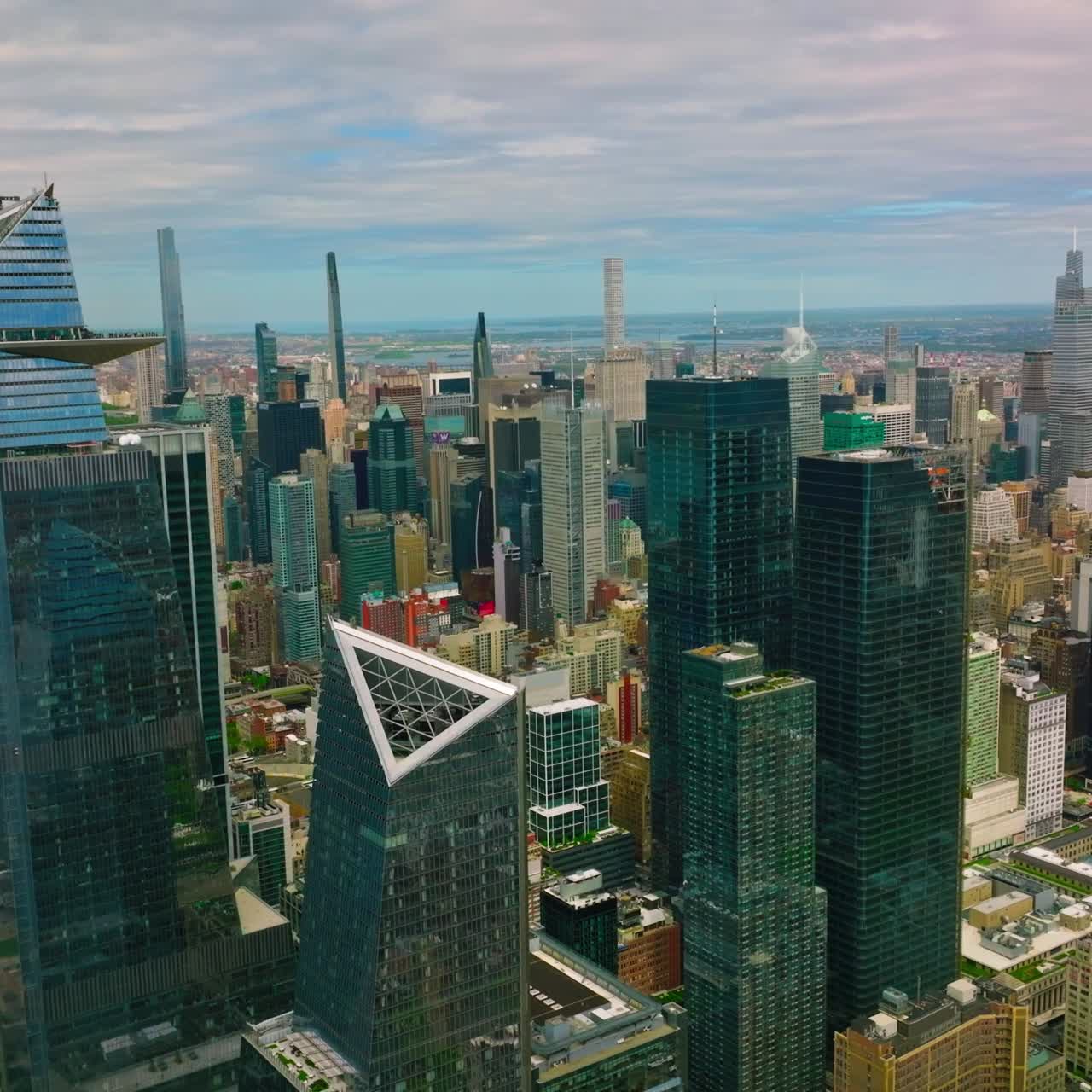 Stunning view of the modern architecture of New York. Mirror skyscrapers towering over the city. Cloudy blue sky backdrop