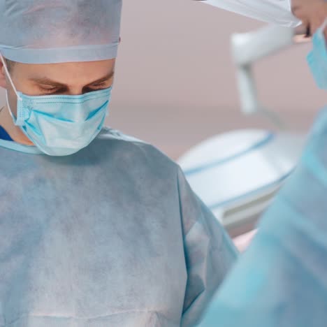 doctor and a nurse in protective uniform and masks. two surgeons perform an operation. close-up.