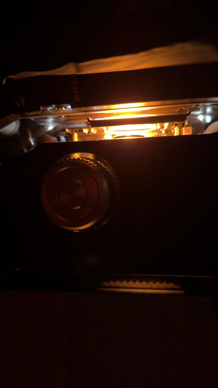 Vintage Projector with Warm Orange Light Glowing in the Dark