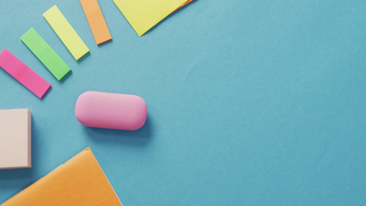 video de post it, borrador y otros equipos escolares en superficie azul