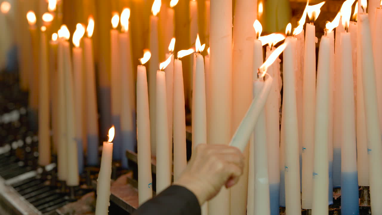 Lighting a votive candle in the sanctuary of Lourdes
