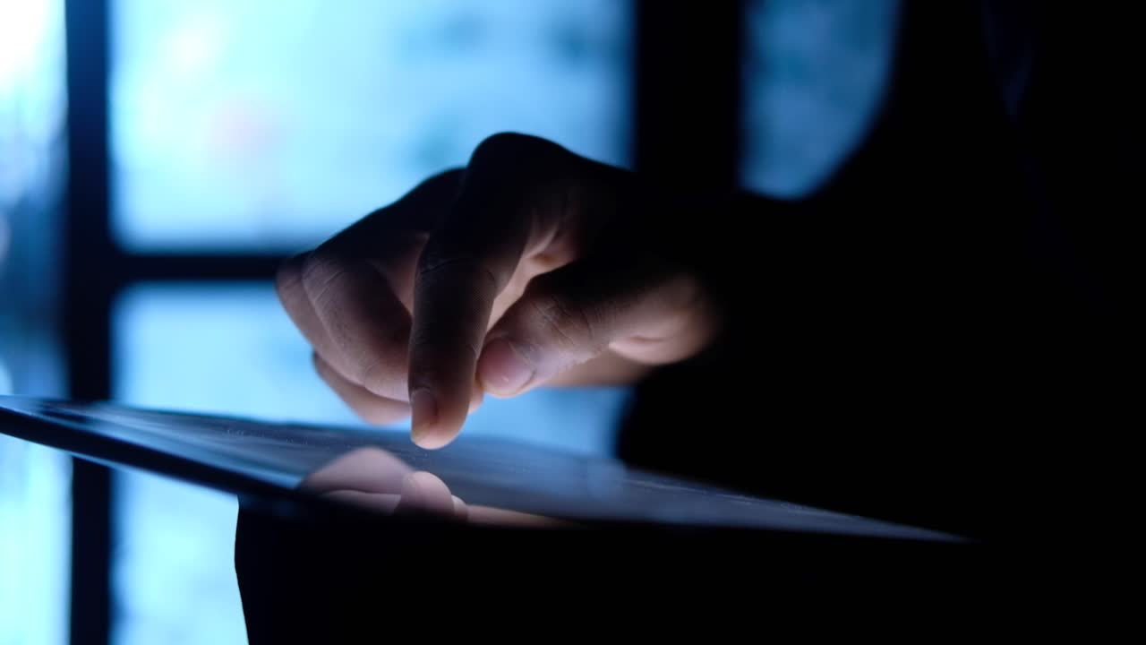 persona que usa una tableta por la noche