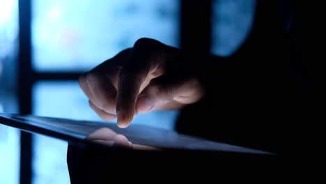 persona que usa una tableta por la noche