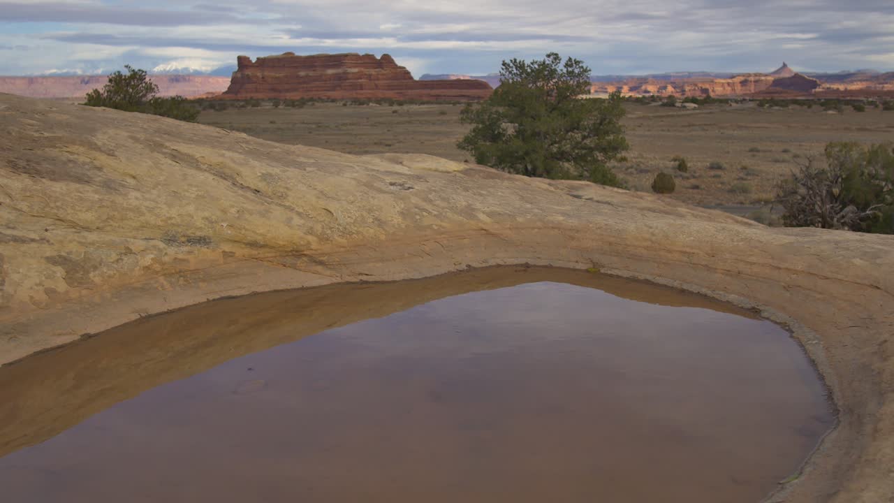 Calando dall'orizzonte del deserto dello Utah verso una pozza d'acqua.