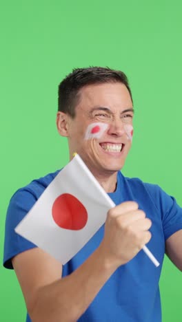 man cheering for japan waving a national flag looking away