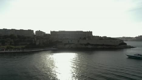 Aerial-Shot-flying-up-over-the-sea-towards-an-old-building-on-the-edge-of-a-peninsula