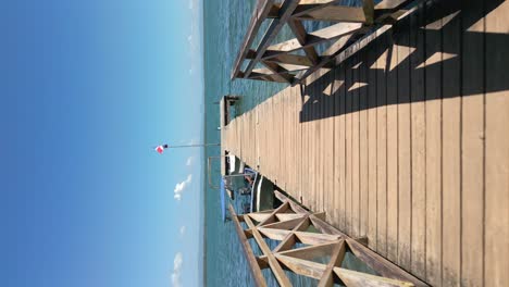 Aerial-shot-of-a-hot-pier-with-boats-anchored-by-a-private-beach-in-the-San-Lorenzo-Bay-area-of-Los-Haitises-National-Park,-Dominican-Republic