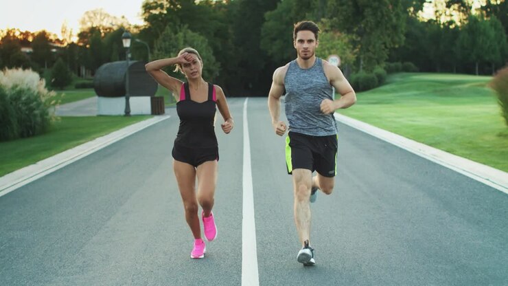Sport couple run together in park. Young people jogging together