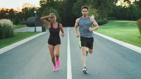 Sport-couple-run-together-in-park.-Young-people-jogging-together