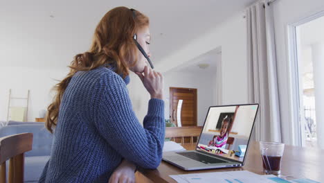 maestra caucásica con auriculares de teléfono haciendo una videollamada con una chica en una computadora portátil en casa