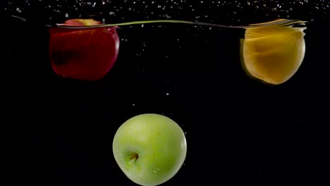 Colorful-green-apple-being-dropped-into-water-in-slow-motion